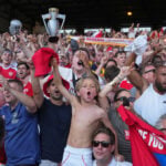 Kroenkes watch on as Arsenal's players finally get their hands on the Premier League trophy