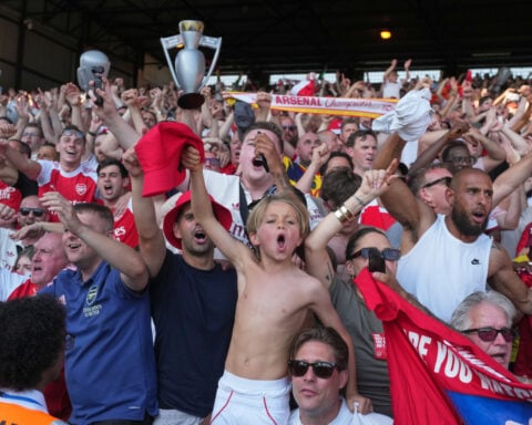 Kroenkes watch on as Arsenal's players finally get their hands on the Premier League trophy