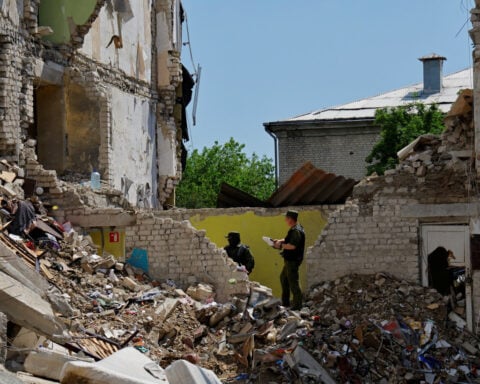 Forensic experts sift through ruined dormitory in Russian-held Luhansk region