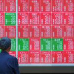 Asian shares are mostly higher, tracking Wall Street's fresh records, and oil prices fall