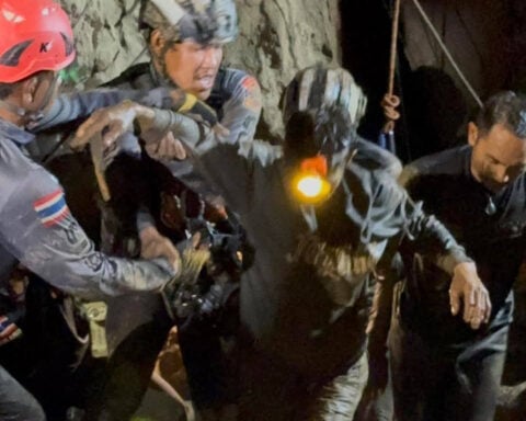 Rescuers evacuate the first of 5 villagers found trapped in a cave in Laos; 2 still missing