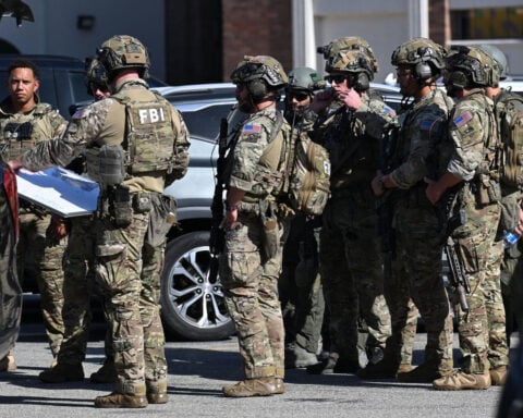 Two hostages are released, but standoff with man after bomb threat at California bank building stretches on