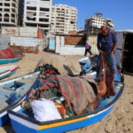 Gazan fishermen patch up dinghies with door frames to keep themselves afloat