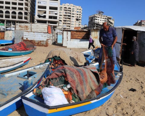 Gazan fishermen patch up dinghies with door frames to keep themselves afloat