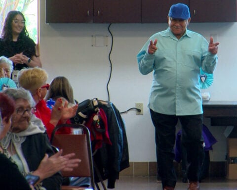 Father's Day fashion show participants model clothing made by senior center's sewing group
