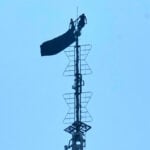 2 people hang banner about 'the power of love' on Empire State Building antenna