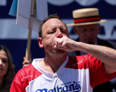 Eating champion Joey Chestnut defends title but blames heat for lower hot-dog tally