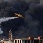 Greek firefighters battle fire at business site, at least two injured
