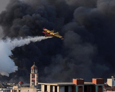 Greek firefighters battle fire at business site, at least two injured