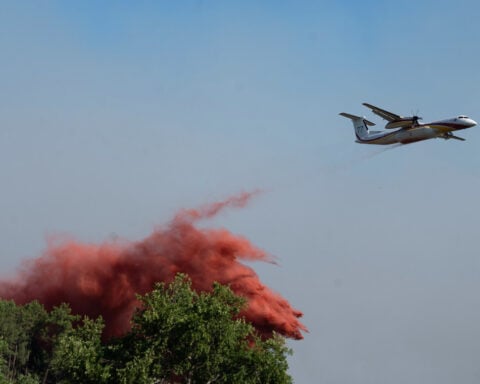 More than 200,000 people flee raging wildfires in France and Spain, some escaping by boat