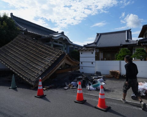 Rescuers search for survivors after a 7.1 quake kills 18 in southwestern Japan