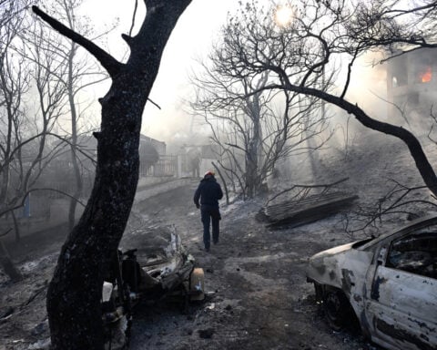 Firefighters battle wildfires in Belgium and Greece as 2 die on an island near Athens