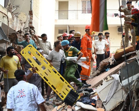 Building collapse in New Delhi kills 1 and traps dozens of others
