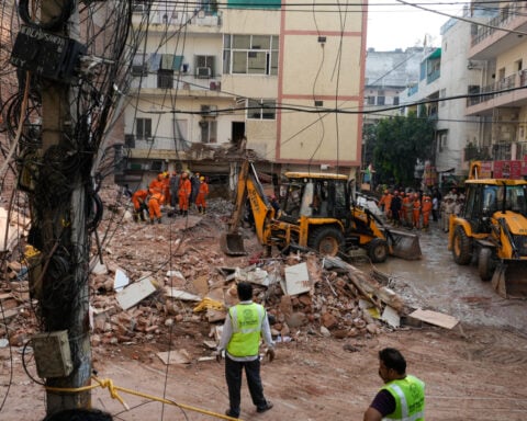 Rescuers search for people trapped in a New Delhi building collapse as death toll rises to 6