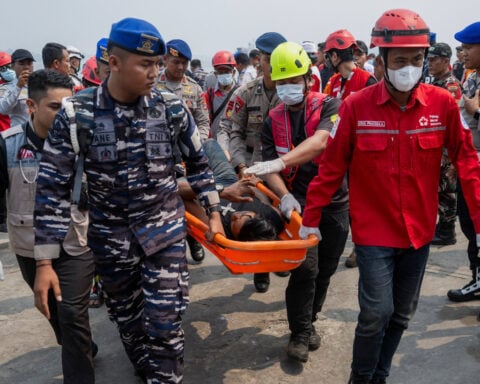 Indonesian rescuers plan to right capsized ship as weather hampers search for 129 missing people