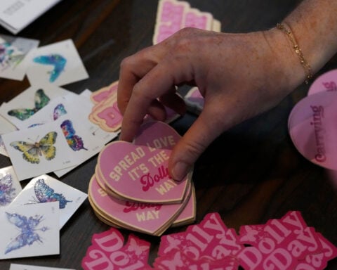It's officially Dolly Parton Day, with parades, pink lights and book drives