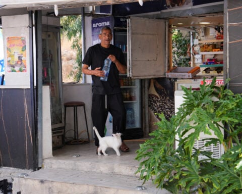 Israeli settlers flank Palestinian cafe with dozens of Israeli flags